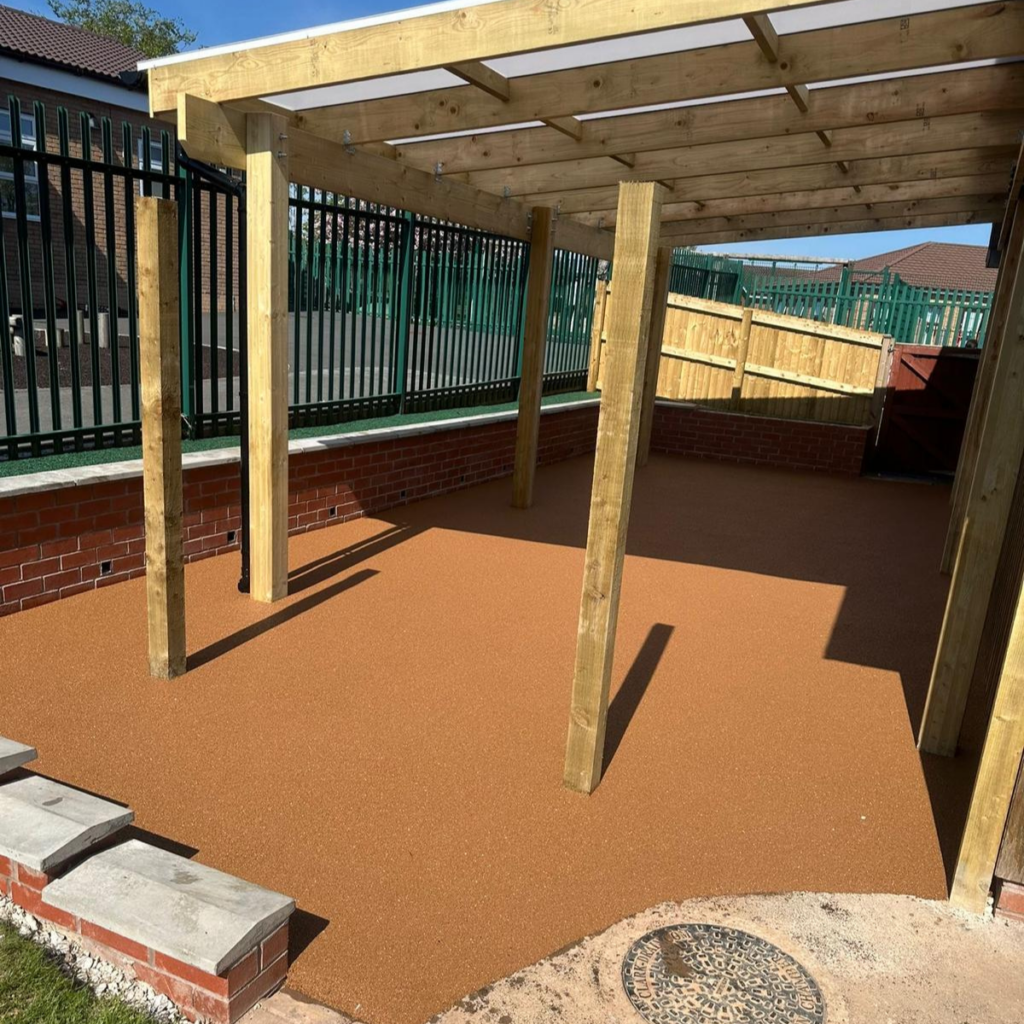 An new playground area showing wet pour rubberised surface and a wooden canopy.