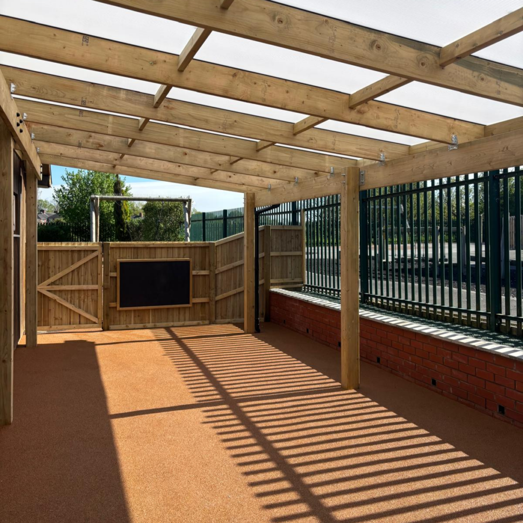 An outdoor classroom at a local nursery with a chalkboard fitted to a new fence.