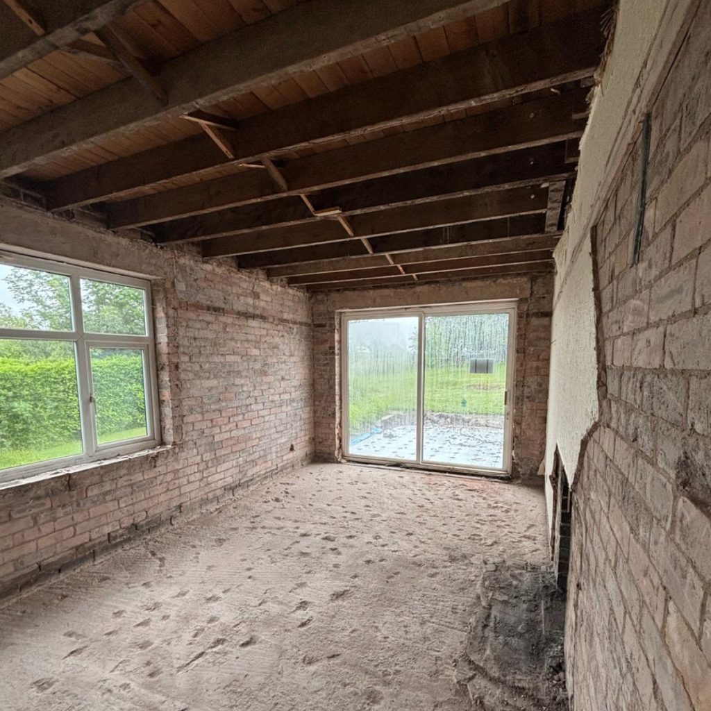 A room that has been taken back to brick with the flooring removed