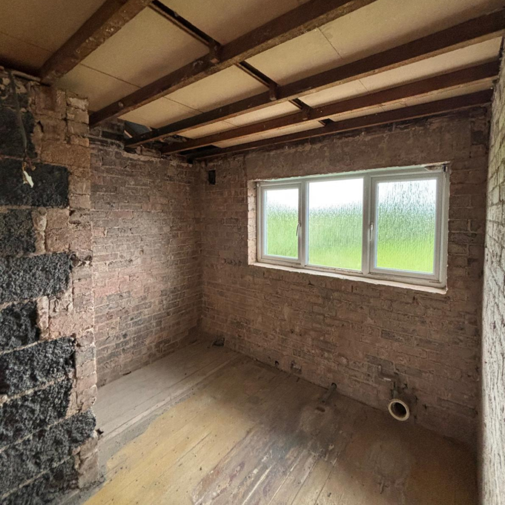 A bathroom that has been taken back to brick