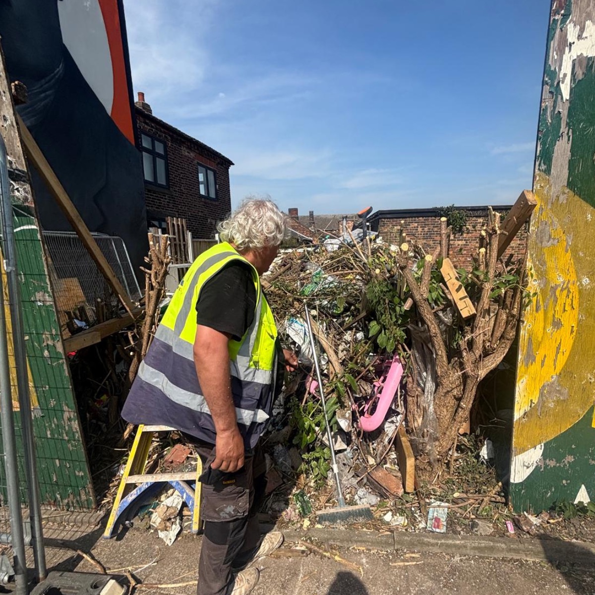 Operative clearing waste and overgrowth during a site clearance in Stoke-on-Trent